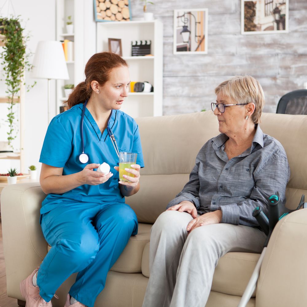 Female doctor talking with senior woman in nursing home about new drug pills